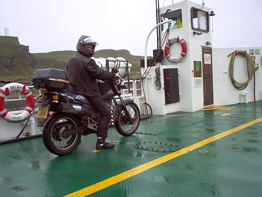 A young Ren sat astride an SLR650 on a small ferry to the isle of Luing