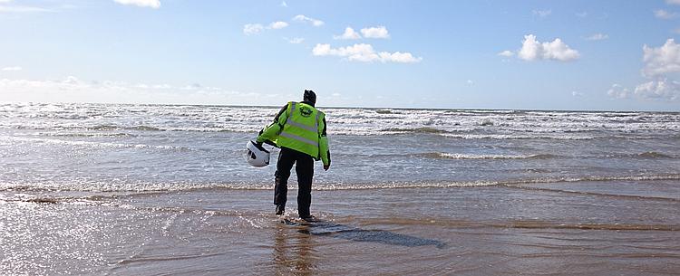 Ren wearing his bike gear while paddling in the water at Rhossili beach
