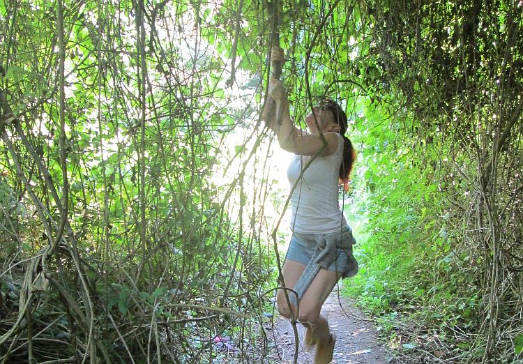 Sharon pretends to swing from a branch in her best Lara Croft outfit and style
