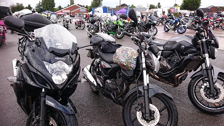 Sharon's little RKS125 among larger motorcycles at the wet All Female Biker Meet