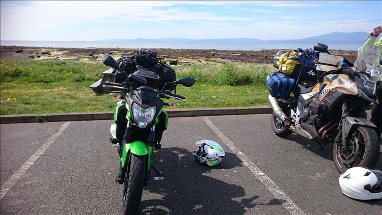 Sharon's 250 with wobbly luggage, calm waters firth of clyde and arran in the hazy distance