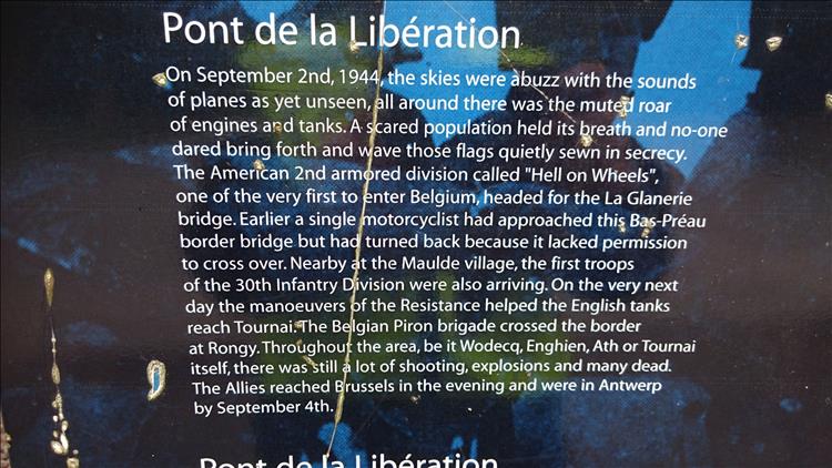 A sign in English telling the tale of an American WW2 motorcyclist accidentally came in to liberate belgium