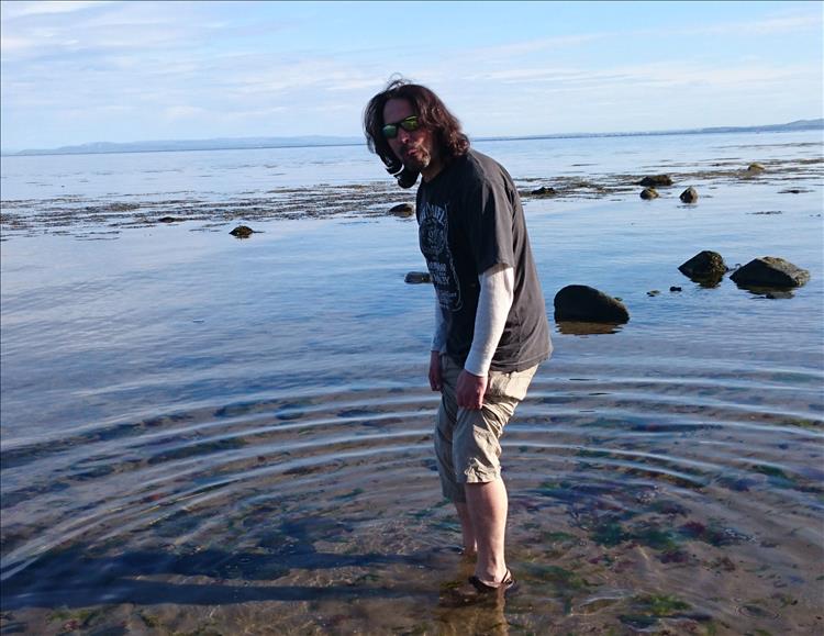 Ren is paddling in the cold but totally calm waters at Bracken bay