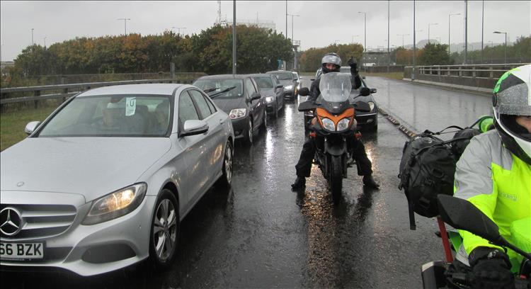 A rider on his Suzuki give a big thumbs up in the pouring rain while queuing for the Erutunnel