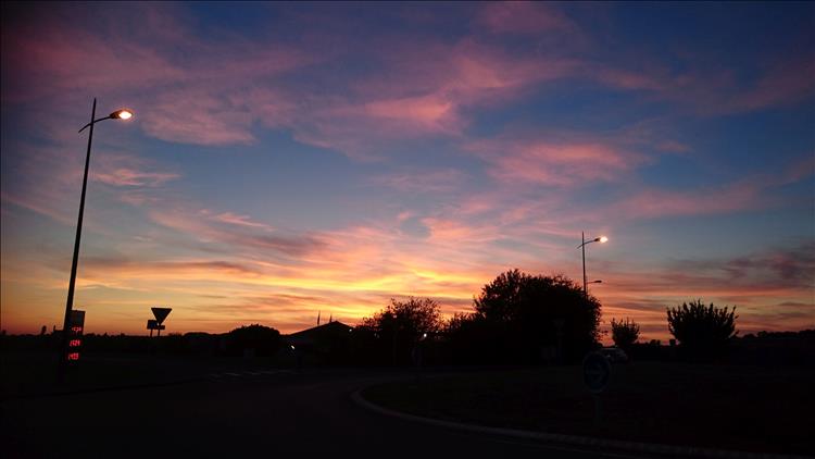whispy clouds, darkening skies, lampposts, and the outlines of buildings in Arleux 