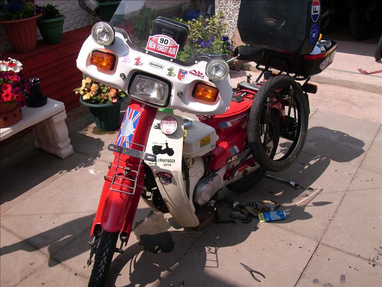 A C90 with a few bits of kit and even a spare tyre in a small garden while Bogger fixes it