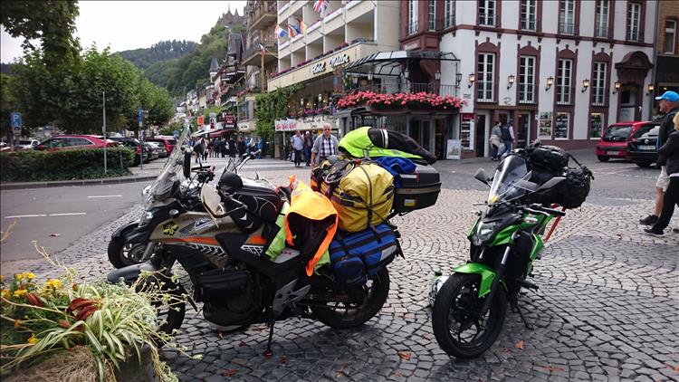 CB500X and Z250SL camping luggage on the main street of Cochem with all the tourists