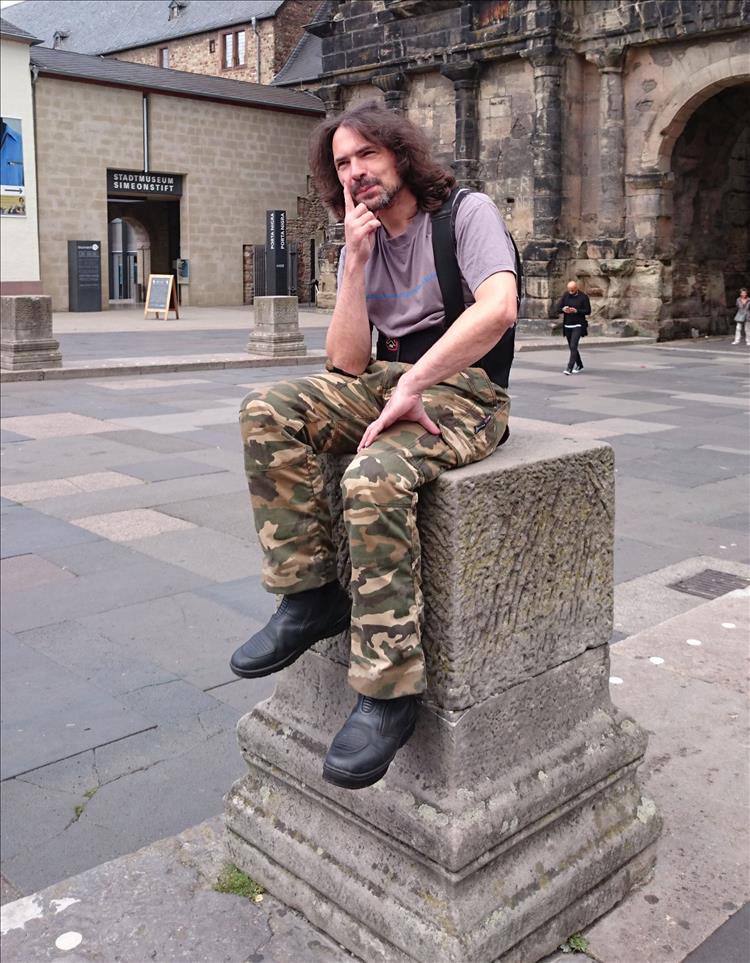 Ren makes like a thinker sitting on a stone plinth from Roman times