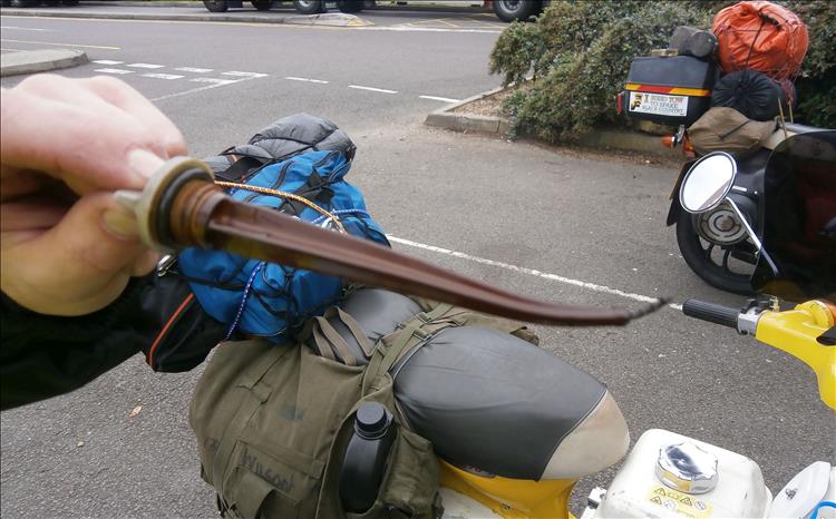 A plastic dipstick with a burned tinge and a melted bent tip