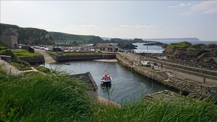 The pretty and quite popular Ballintoy Harbour with a lot of cars in the car park