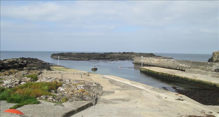 A wall and a slipway and some rocky outcrops form the small harbour at Dunseverick