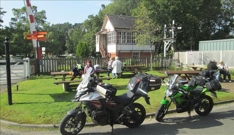 The historic train station at alston and sharon sits on a bench drinking tea