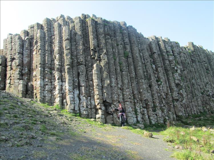 Sharon looks tiny with logn columns of rocks reaching up way above her