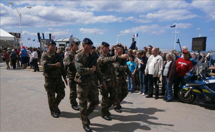 6 modern young soldiers of the French army parading to the gathered crowd