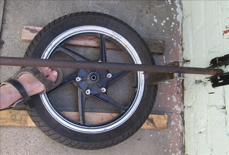 The wheel is supported on 2 lengths of wood to keep it off the floor and prevent scratching