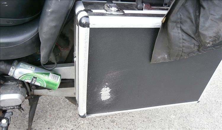 A travel case being used as a pannier has a patch of scratching after the crash