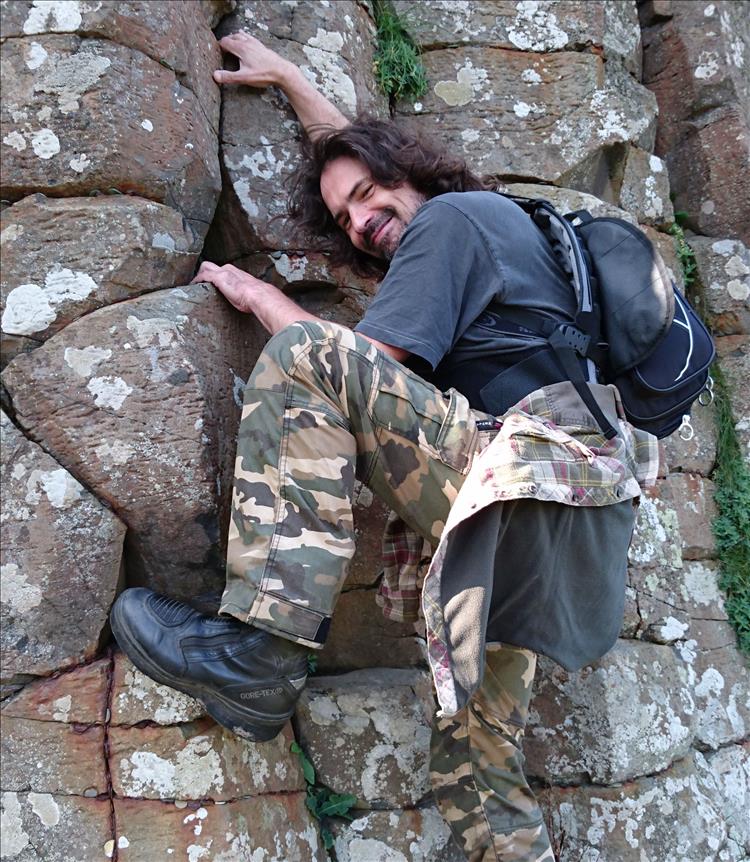 Ren, complete with shaggy hair, climbs rocks at giant's causeway