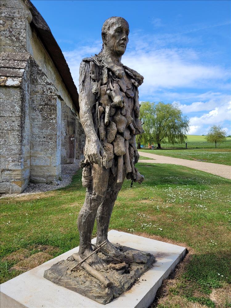 A human figure covered in lumpy bits is outside the Gallery at Messums