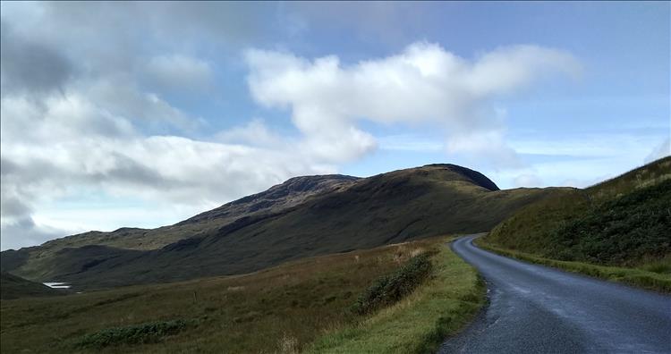 A narrow lane winds up the side of steep hills and deep valleys on Mull