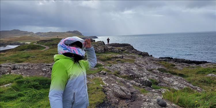 Sharon looks out to see, posing in a silly fashion on the rocks by the Lighthouse