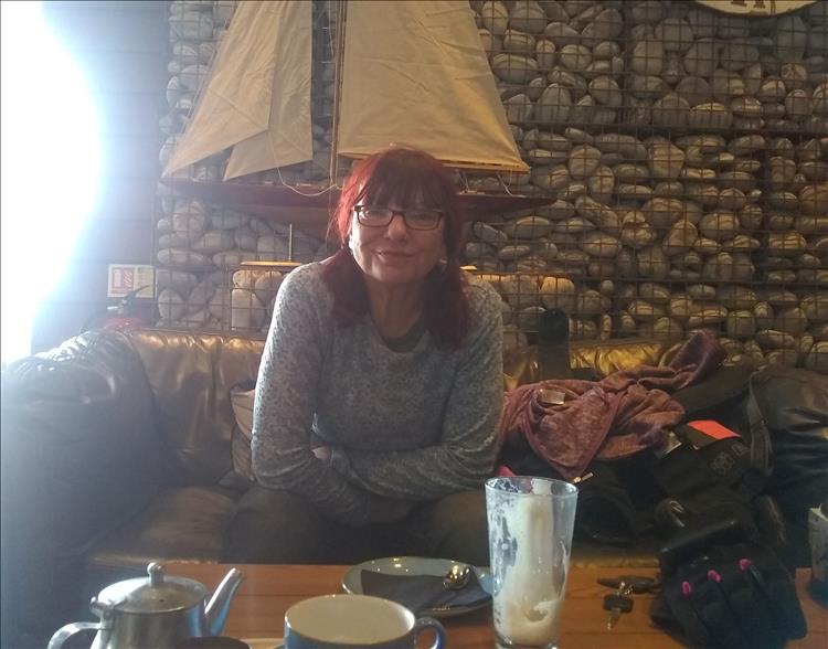 Sharon sits in the smart stylish bar with coffee and a smile