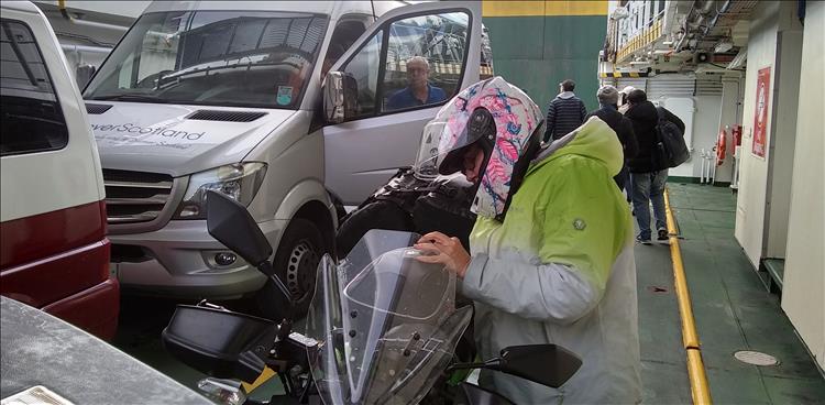 Sharon digs into her tank bag while on the ferry, there's plenty of vehicles on the deck
