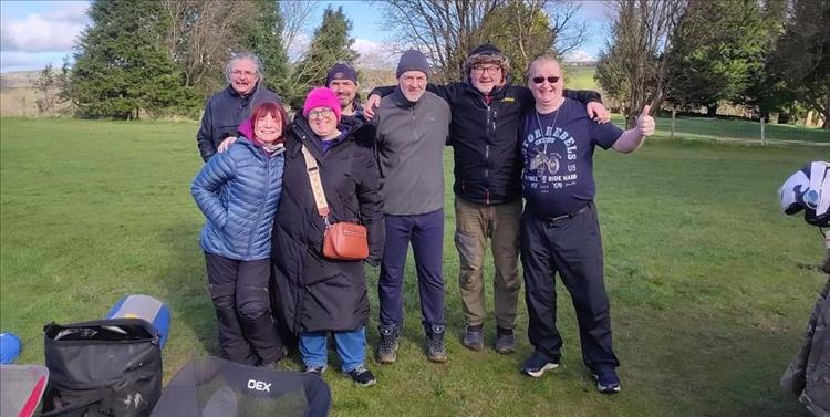 7 friends all waving at the camera on Y Giler campsite