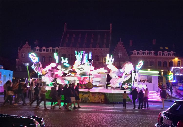 A blurry nighttime image of the bright lights on a ride in the streets of Ypres