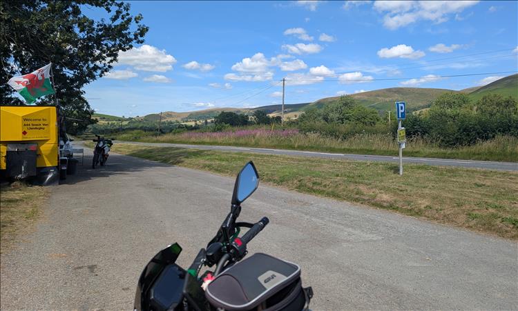 In a layby a bright yellow food van, glorious sunshine, blue skies and bulbous hills