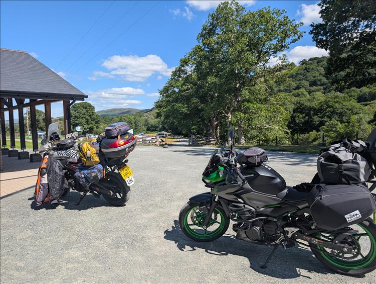 The bikes covered in camping kit, the edge of a modern building, fields filled with tents and wonderful welsh hills
