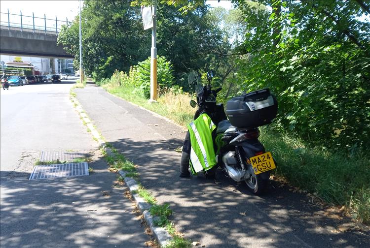A scooter beside the road as bogger waits for his keys to come back