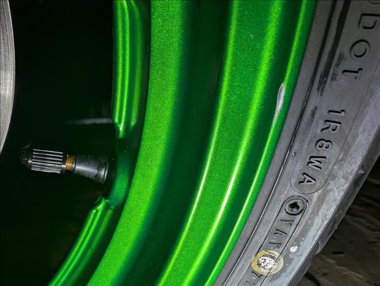 The vibrant lime green wheel rim has a samll chip in the paintwork