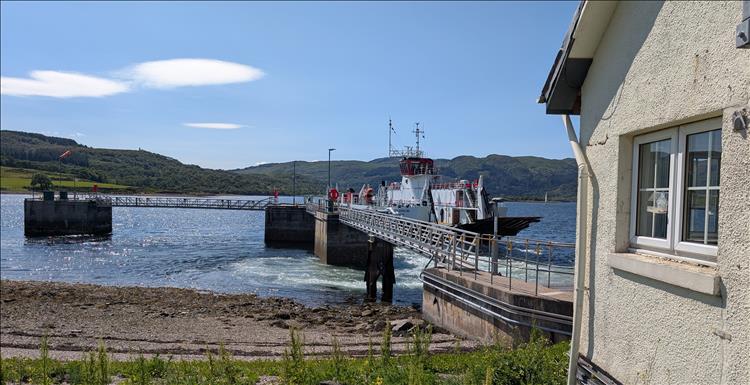 The ferry comes into the ramp, there's hills and blue skies and the loch