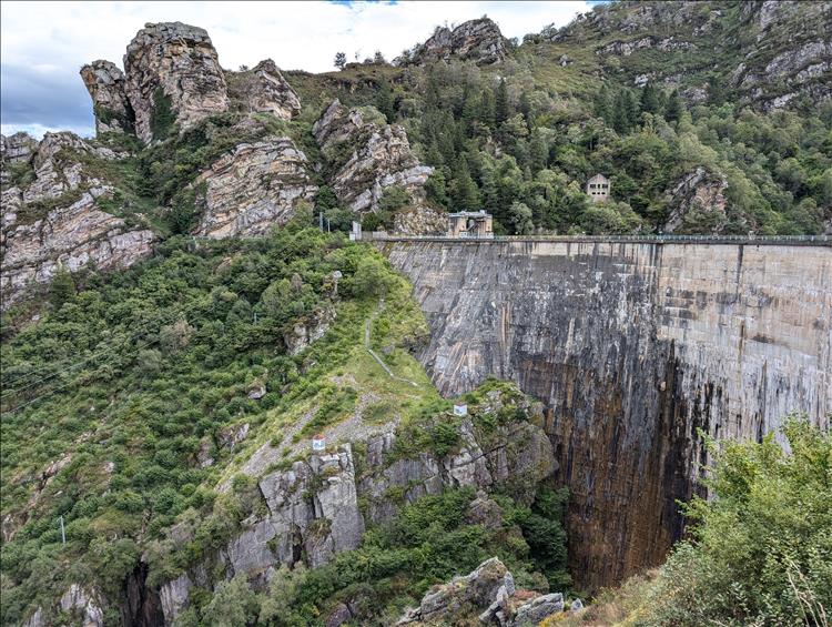 Between gnarly rocks and steep gorge is the dirty grey and wet wall of the dam