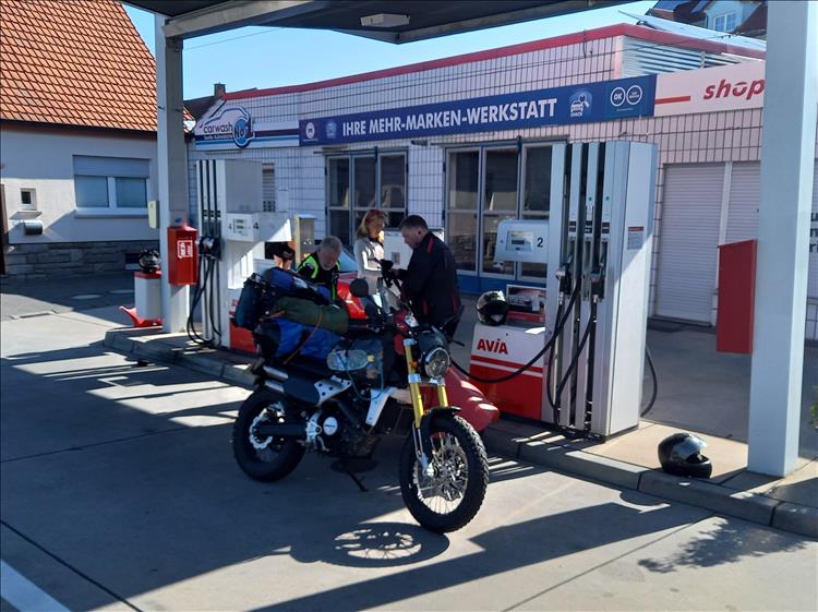 Fantic Cabellero 125 covered in camping luggage at a German petrol station