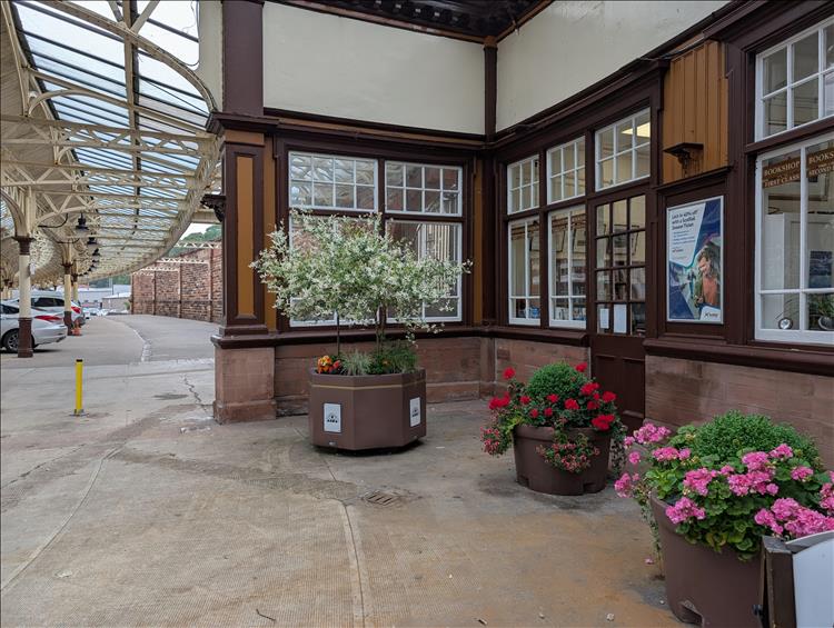 Bright flowers in planters outside offices at the pretty train station