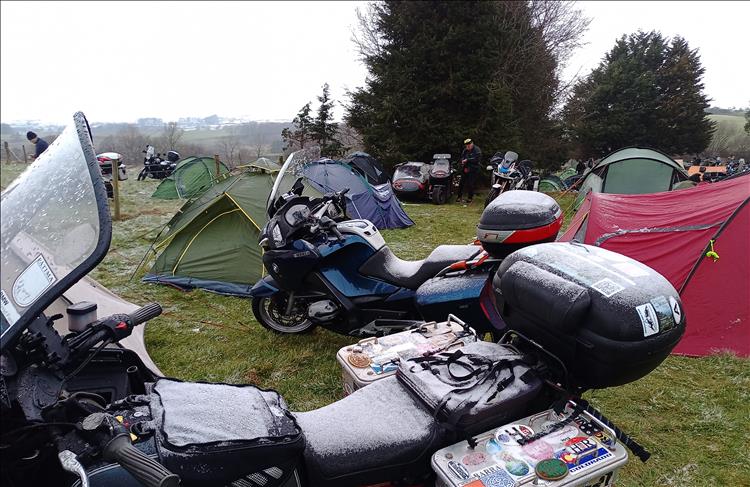 A very thin light dusting of snow on the seats and tanks of the motorcycles