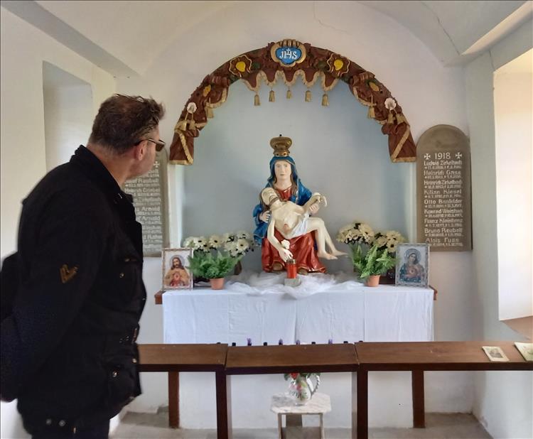 Inside the church a statue of Mary and Jesus, a small alter and bright clean white painted walls