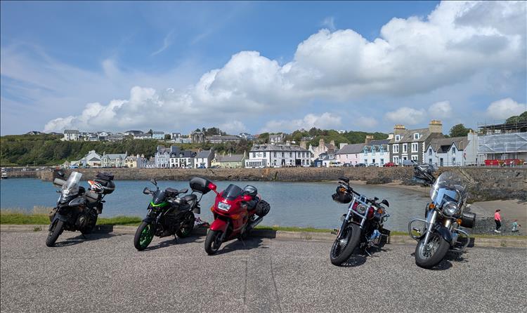 5 motorcycles along the harbour wall, the various houses and buildings of the town behind