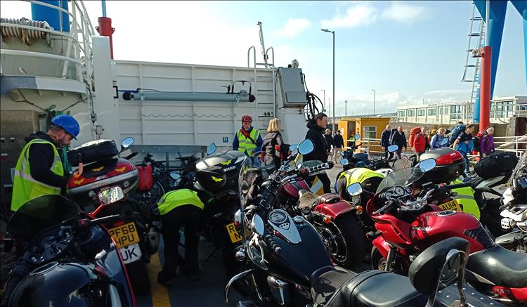 Motorcycles, riders and passengers, deck hands are strapping down the bikes for the crossing