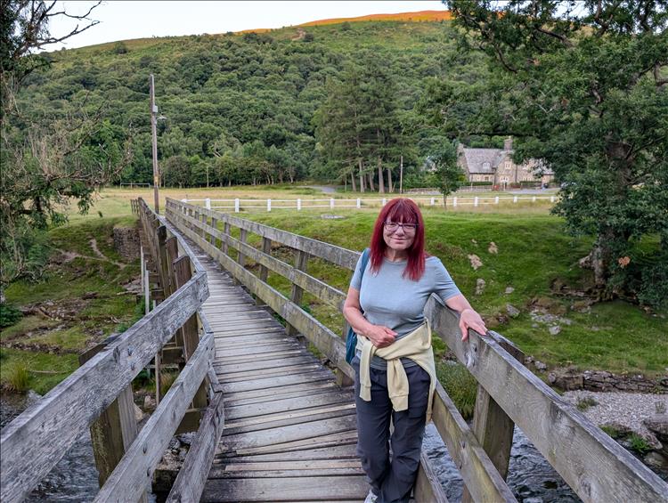 On a rickety wooden bridge Sharon smiles in the beautiful surrounding of the valley