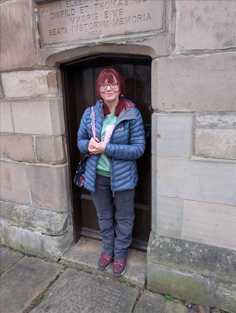 Sharon stands in an old doorway that is barely tall enough for her