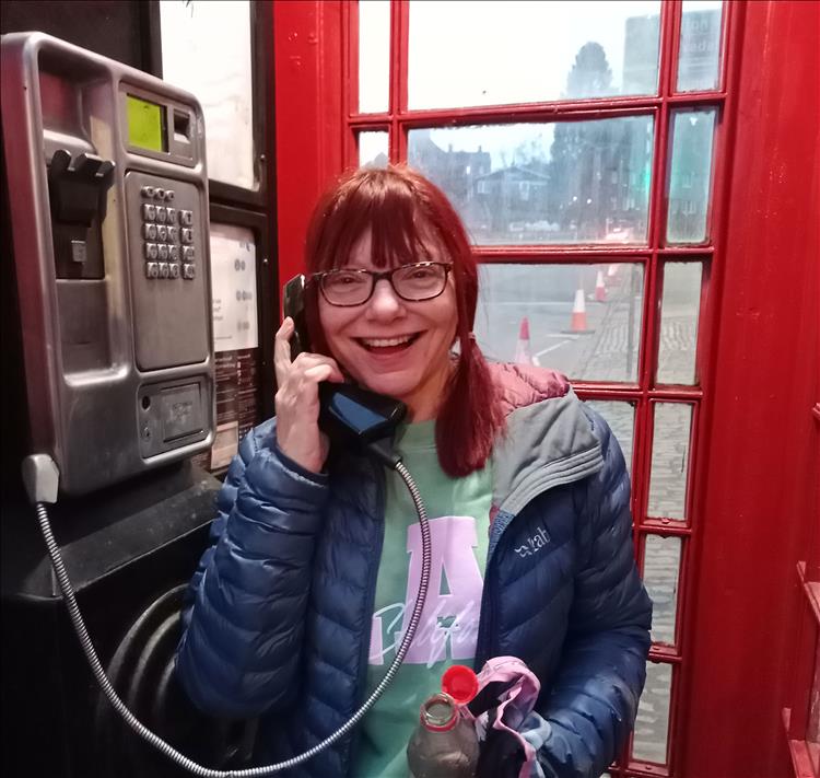 Sharon in the old red phone box that still has a working phone