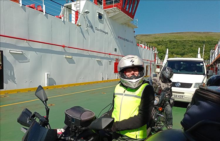 Sharon smiling on the large vehicle deck of the ferry as we cross in the sunshine