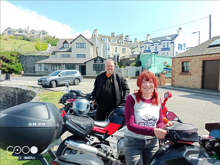 Sharon smiling amidst the bikes and in the sun at Portpatrick harbour