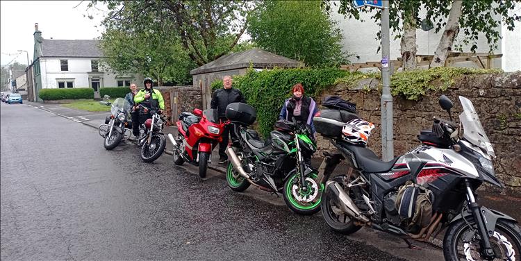 5 motorcycles at the roadside in the small town of Lochwinnoch, in the rain