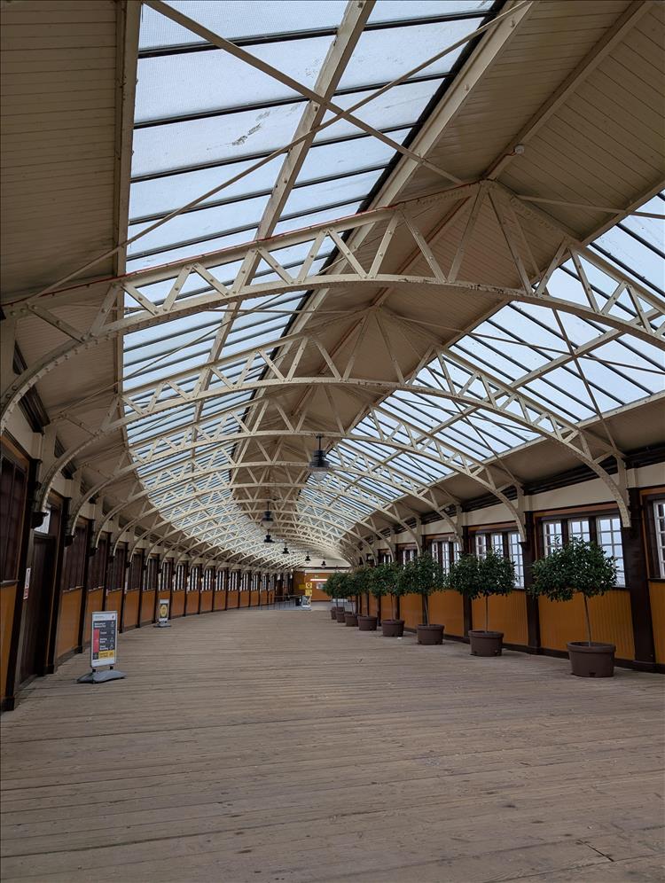 The steel, wood and glass cover curves away at the pretty station