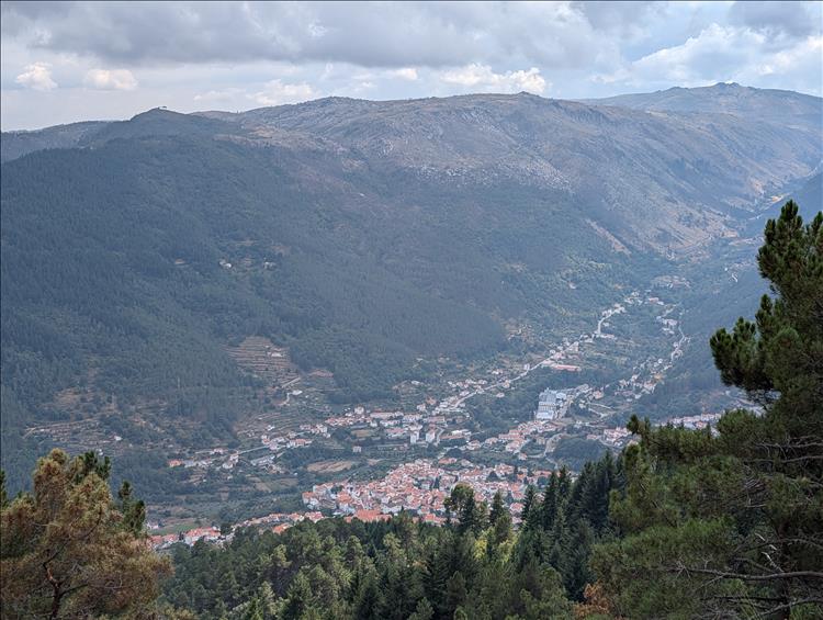 Down in the valley a town, either side massive hillsides at Serra Da Estrela