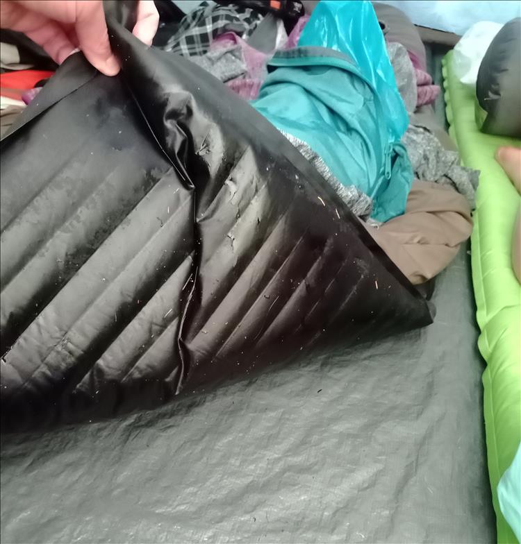Ren lifts the air mattress to show how it is wet and the ground sheet is wet
