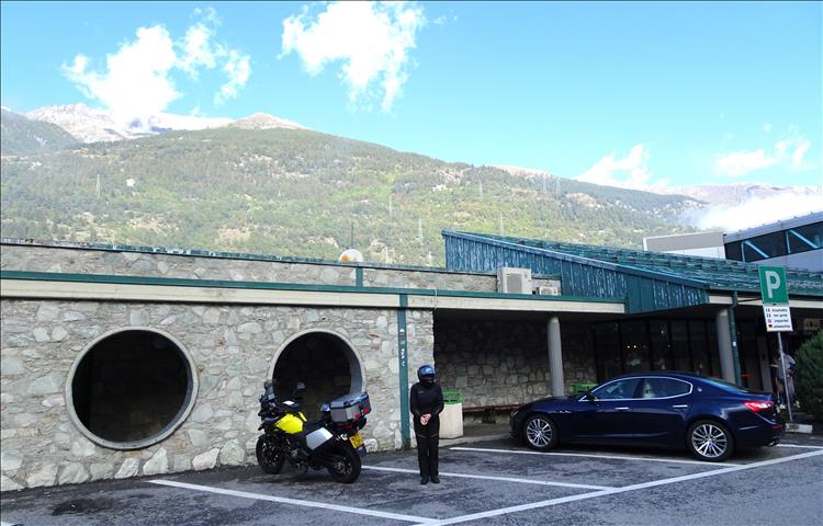 Upt's wife in bike gear, the Vstrom 650 and a dark blue or black Maserati